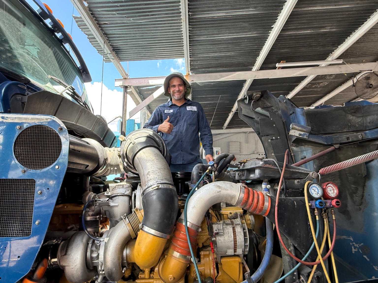 Olansy giving a thumbs up while servicing a commercial truck